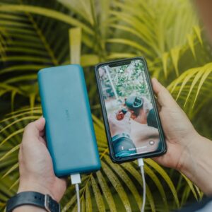 black smartphone and green powerbank close-up photography